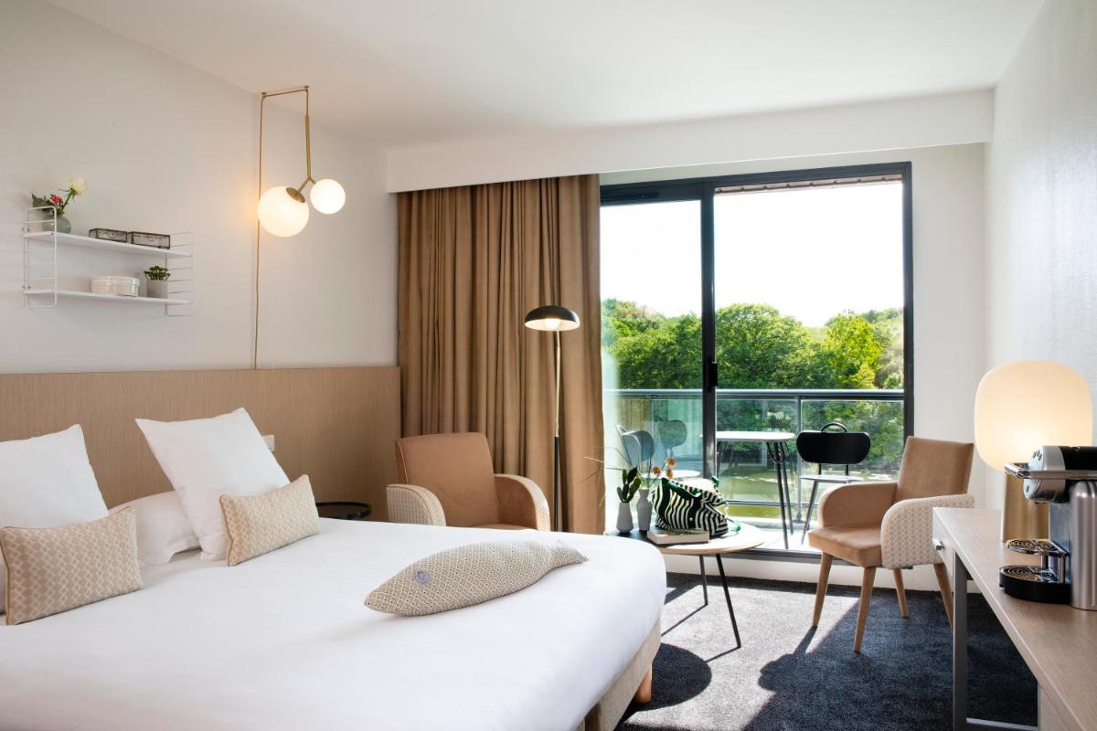 une chambre d'hôtel avec un lit et une grande fenêtre dans l'établissement Best Western Plus Hotel les Rives du Ter, à Larmor-Plage