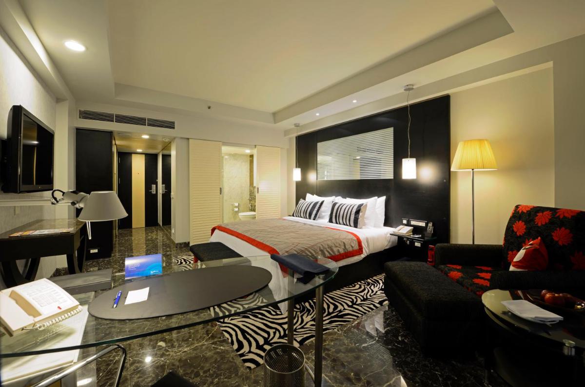 a hotel room with a bed and a desk at Radisson Blu Hotel Ahmedabad in Ahmedabad