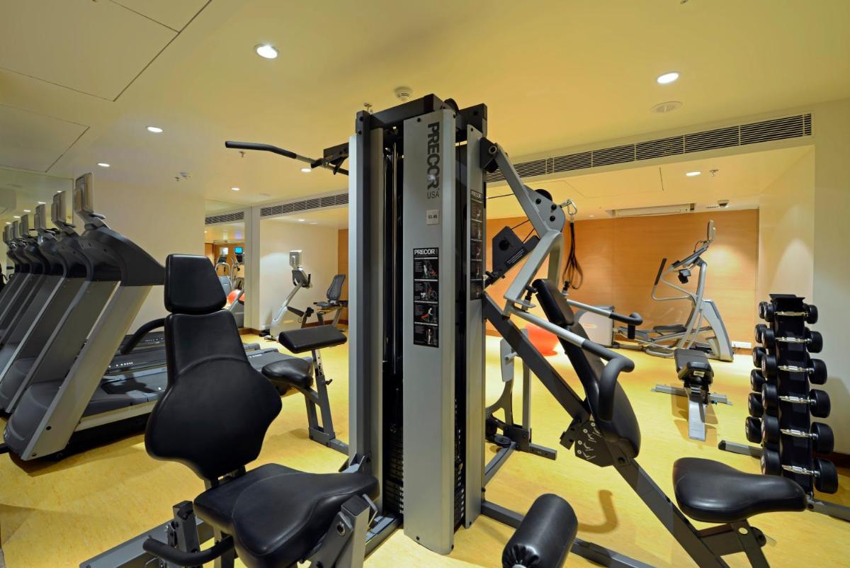 a gym with treadmills and elliptical machines at Radisson Blu Hotel Ahmedabad in Ahmedabad