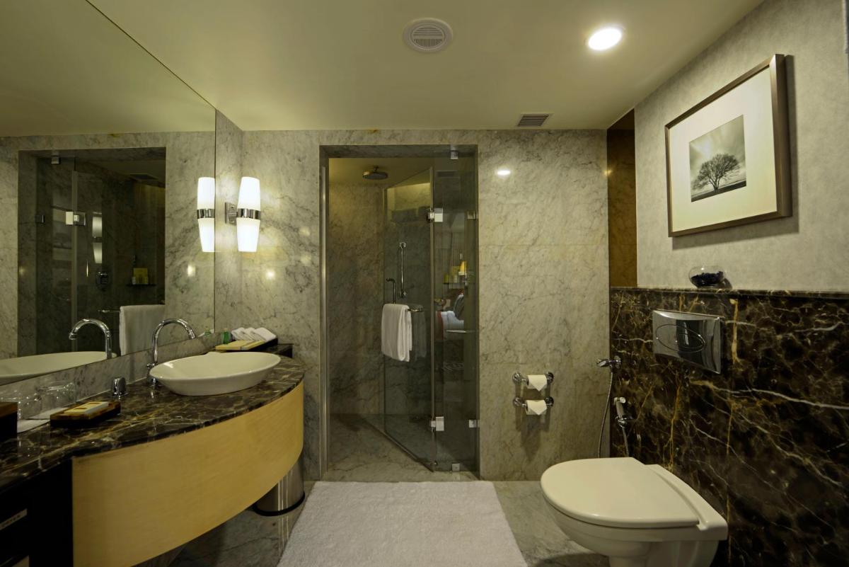 a bathroom with a toilet and a sink and a shower at Radisson Blu Hotel Ahmedabad in Ahmedabad