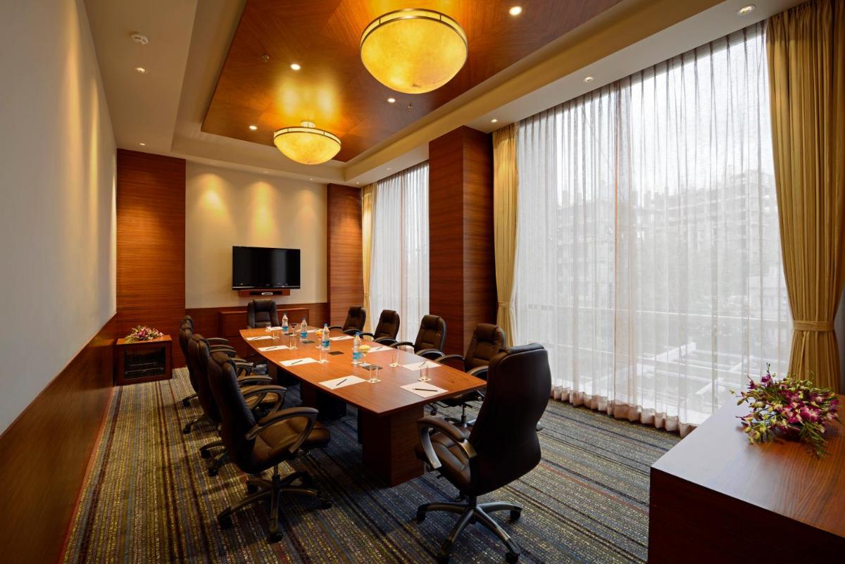 a conference room with a long table and chairs at Radisson Blu Hotel Ahmedabad in Ahmedabad