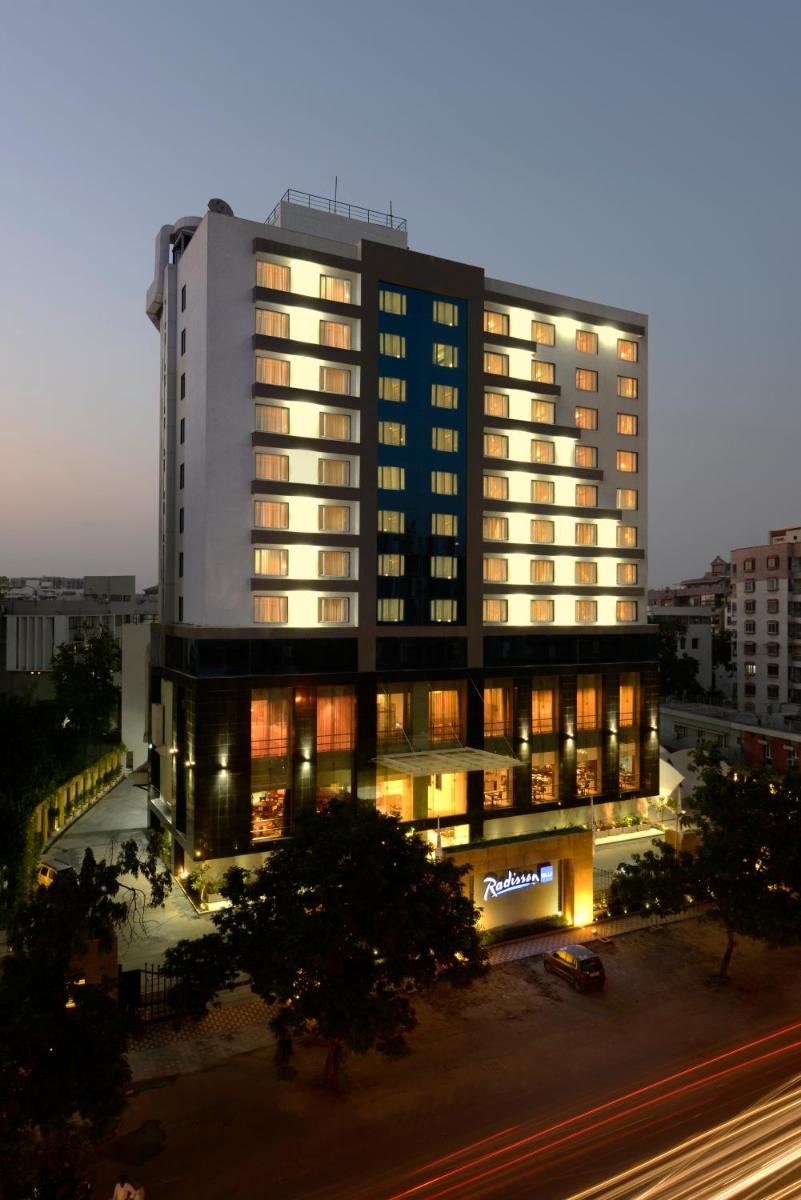 a tall building with lights on in a city at Radisson Blu Hotel Ahmedabad in Ahmedabad