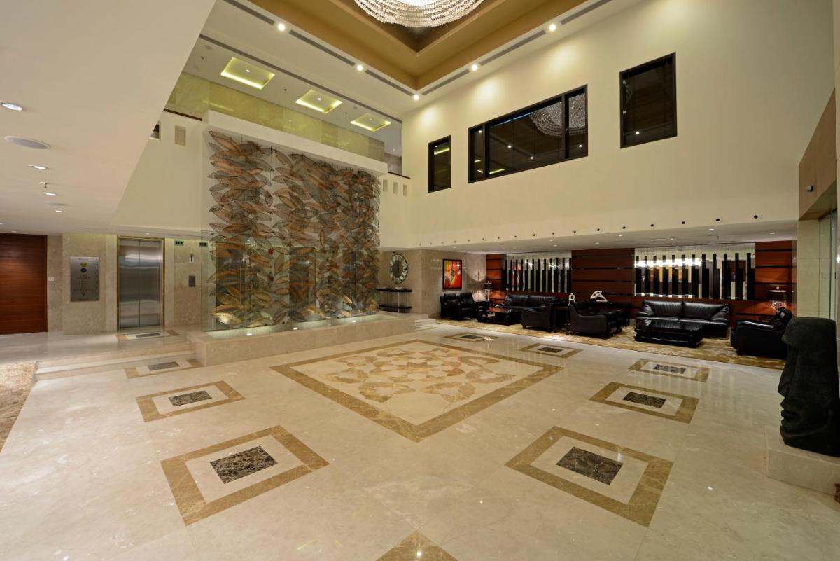 a large lobby with a large room with a fireplace at Radisson Blu Hotel Ahmedabad in Ahmedabad
