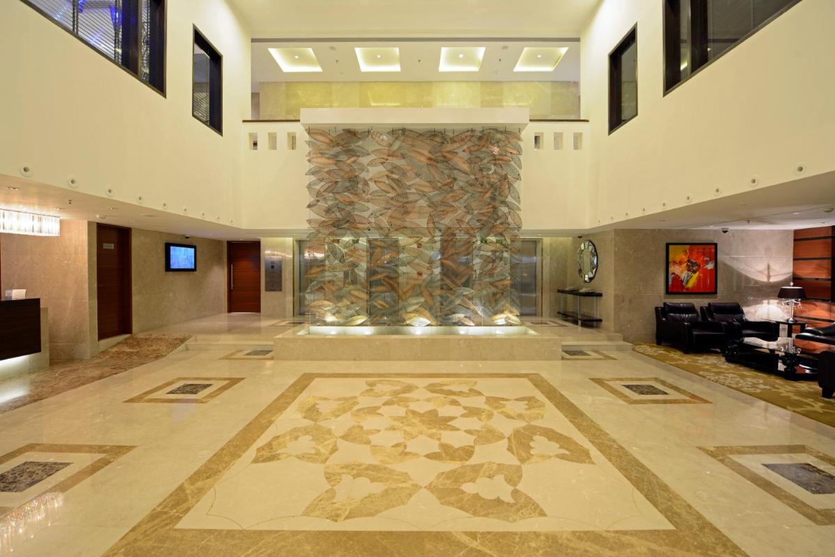 a lobby with a large stone column in the middle at Radisson Blu Hotel Ahmedabad in Ahmedabad