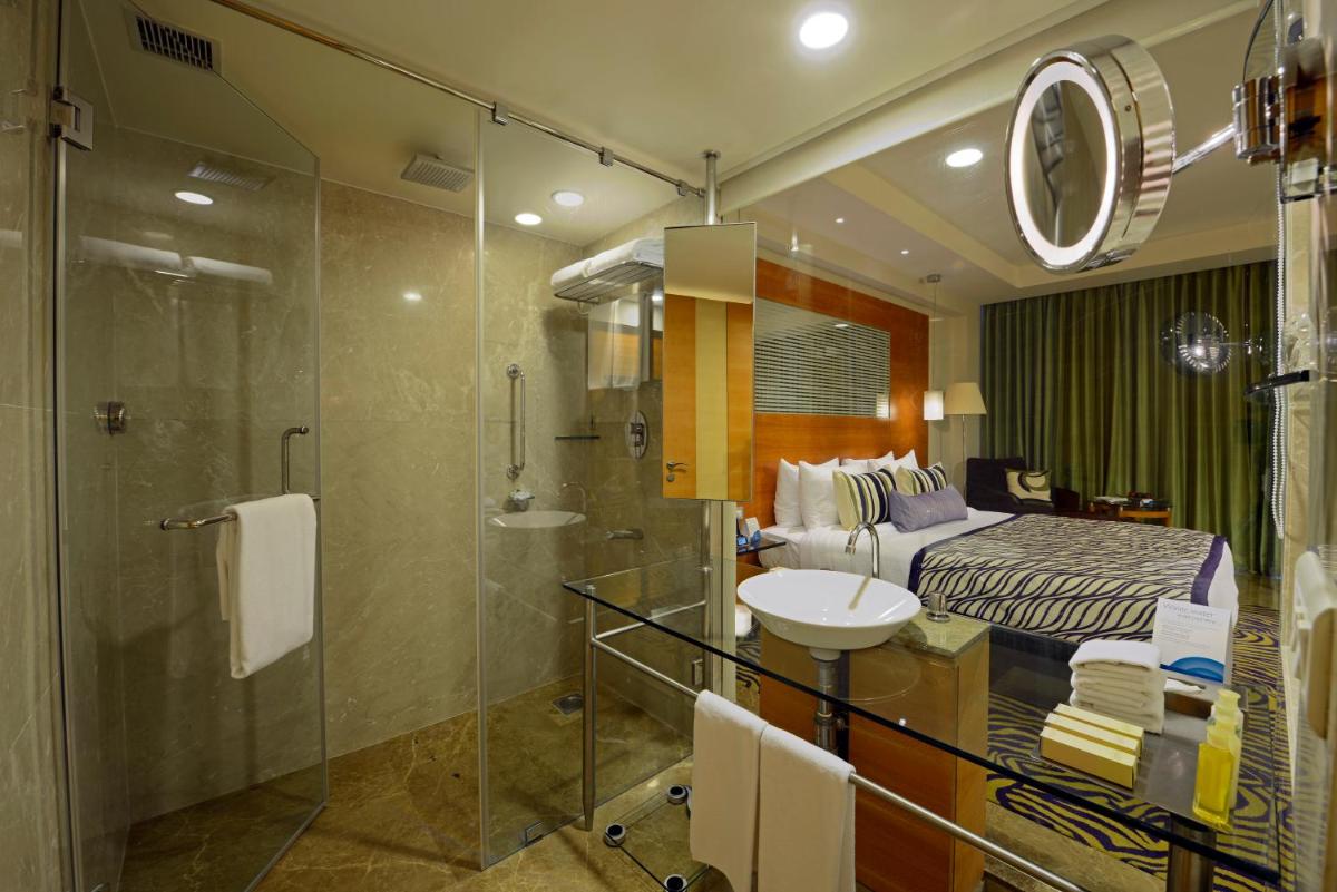 a bathroom with a bed and a shower and a sink at Radisson Blu Hotel Ahmedabad in Ahmedabad