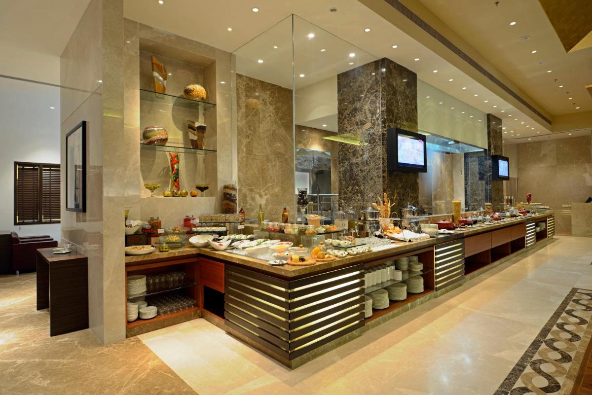 a restaurant with a buffet of food on display at Radisson Blu Hotel Ahmedabad in Ahmedabad