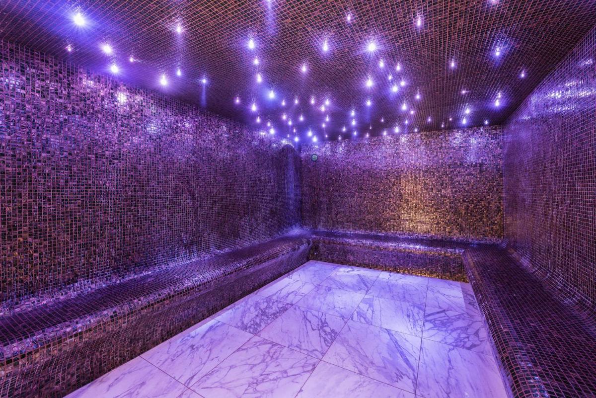 une pièce vide avec des lumières violettes sur un mur dans l'établissement Fahrenheit Seven Courchevel, à Courchevel