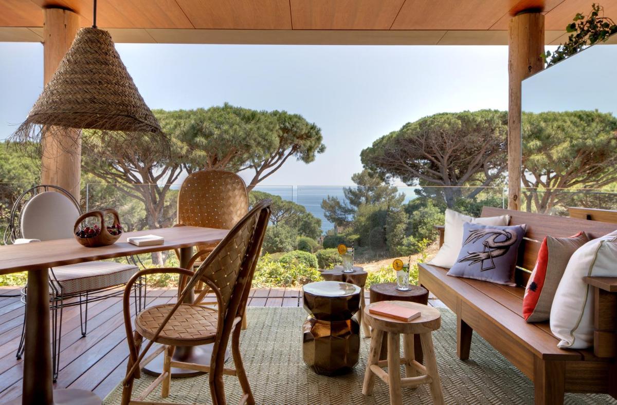une terrasse couverte avec un banc et une table avec vue dans l'établissement Lily of the Valley, à La Croix-Valmer