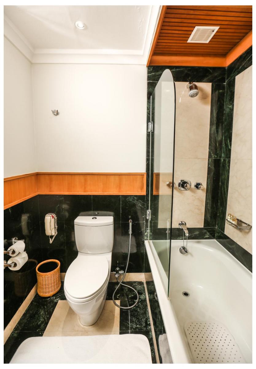 a bathroom with a toilet and a bath tub at Trident Chennai in Chennai
