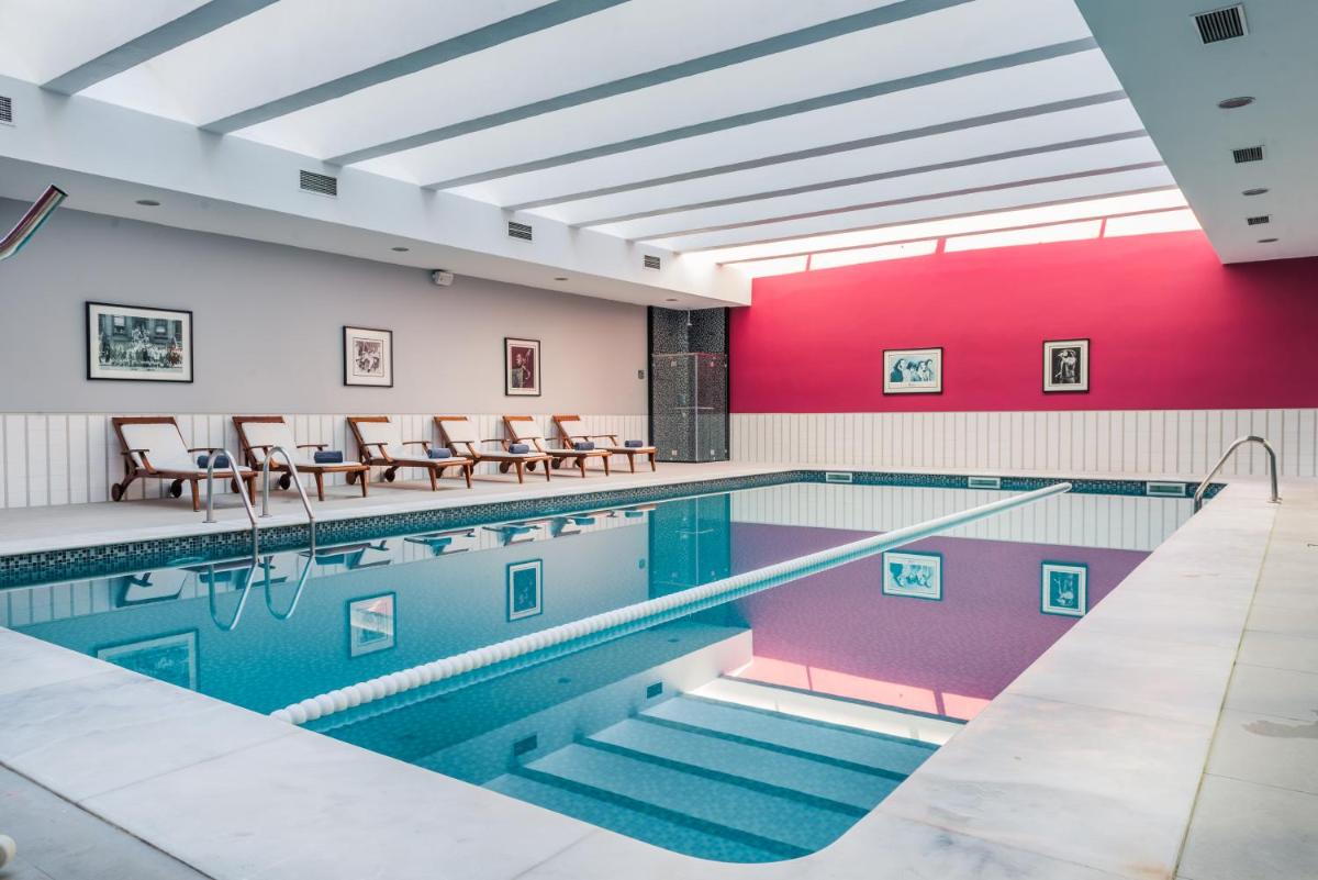 uma piscina com mesas e cadeiras em um prédio em Vila Gale Opera em Lisboa
