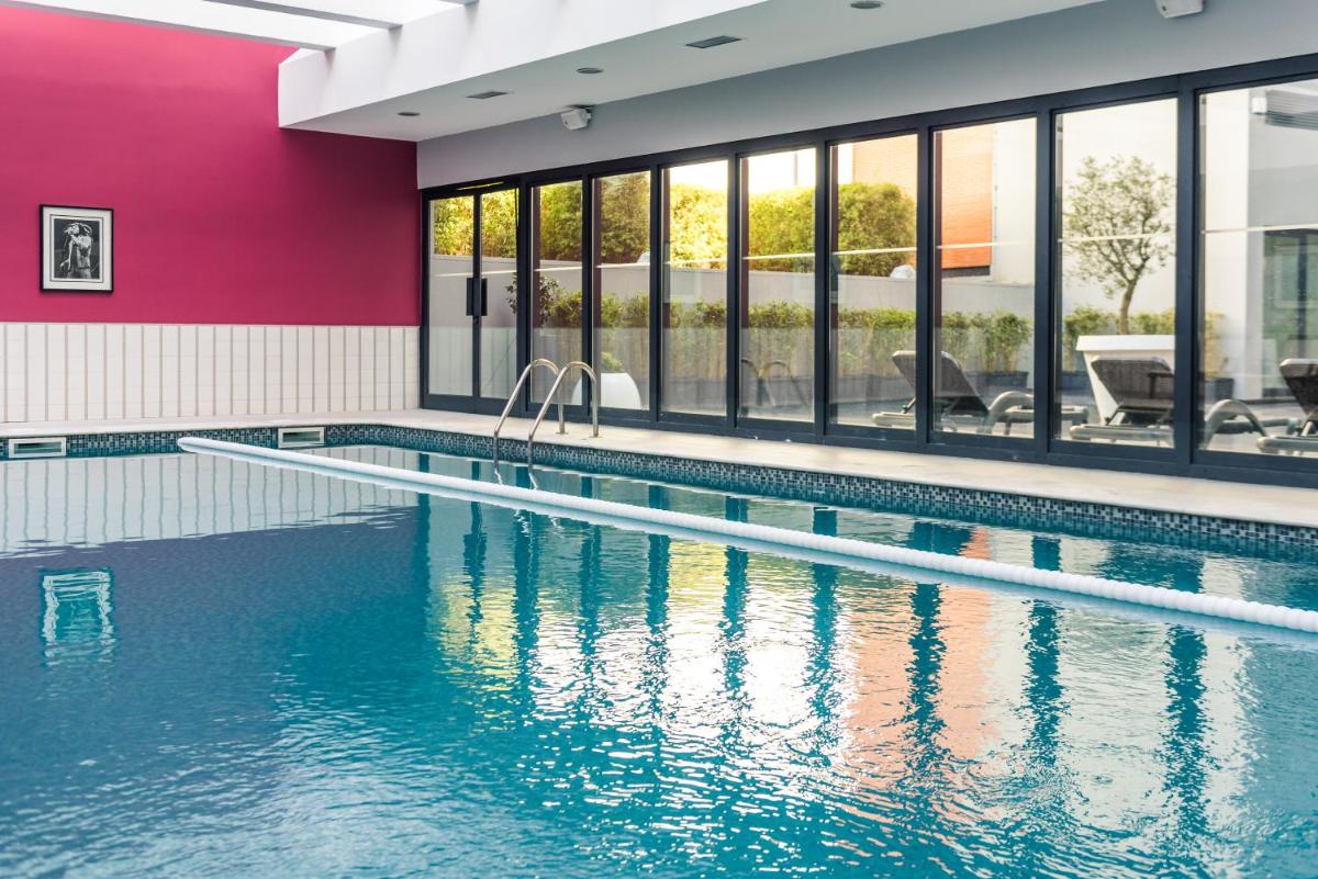 uma piscina com água azul em um prédio em Vila Gale Opera em Lisboa