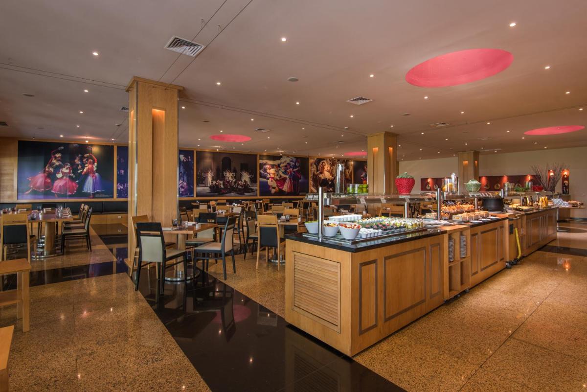 um restaurante com um bar com mesas e cadeiras em Vila Gale Opera em Lisboa