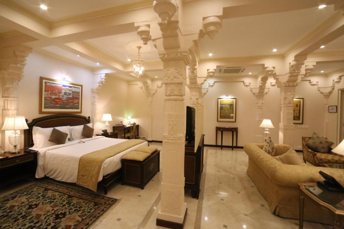 a bedroom with a bed and a living room at Taj Fateh Prakash Palace Udaipur in Udaipur