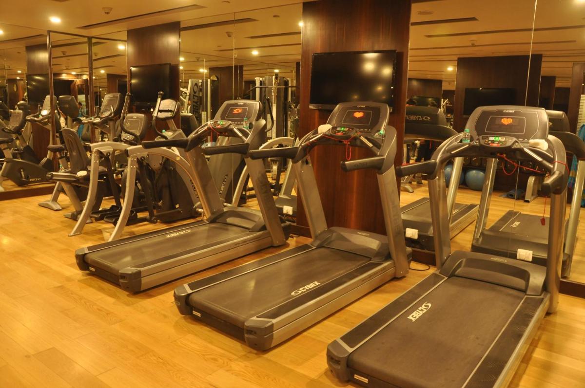 a gym with treadmills and elliptical machines at Radisson Blu Jaipur in Jaipur