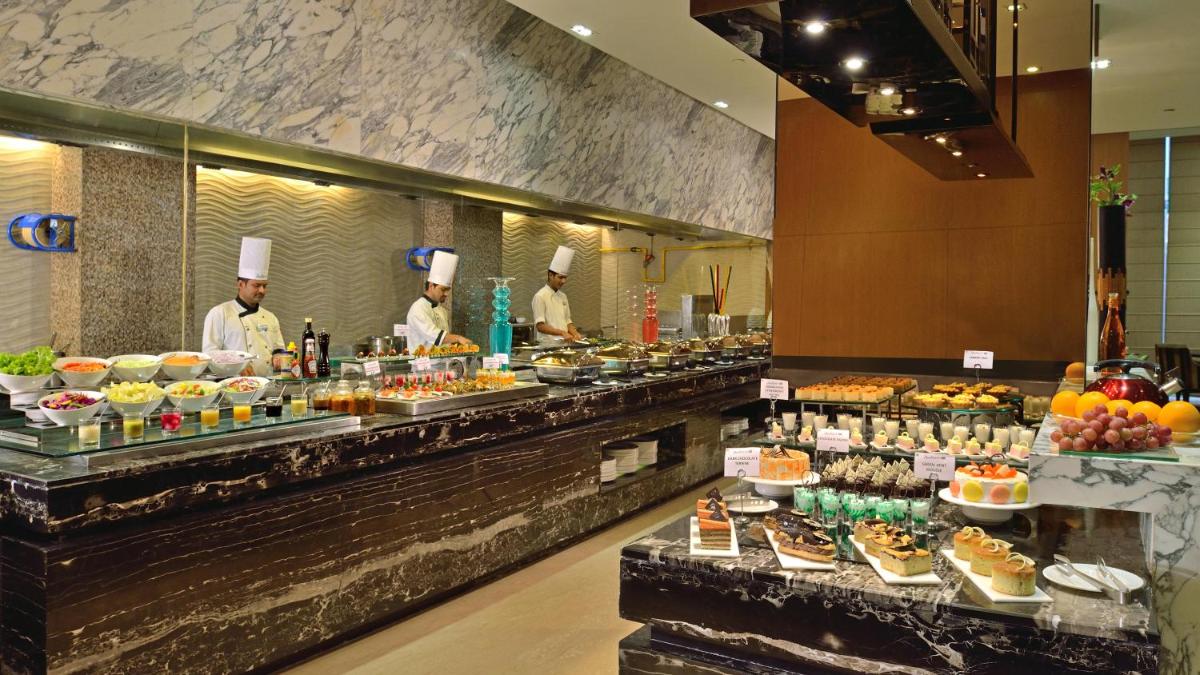 a buffet line in a hotel with chefs preparing food at Radisson Blu Jaipur in Jaipur
