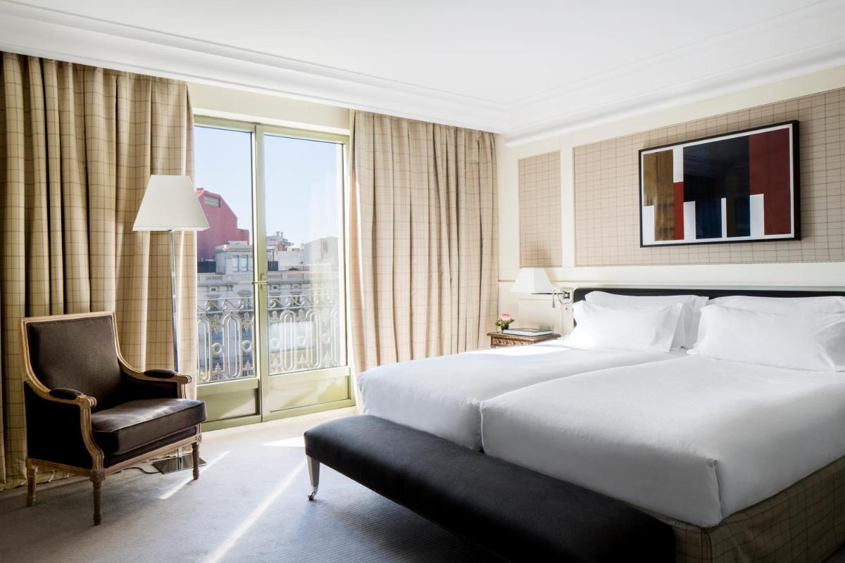 Un dormitorio con una cama y una silla y una ventana. en Majestic Hotel & Spa Barcelona GL, en Barcelona 101 fotos más
