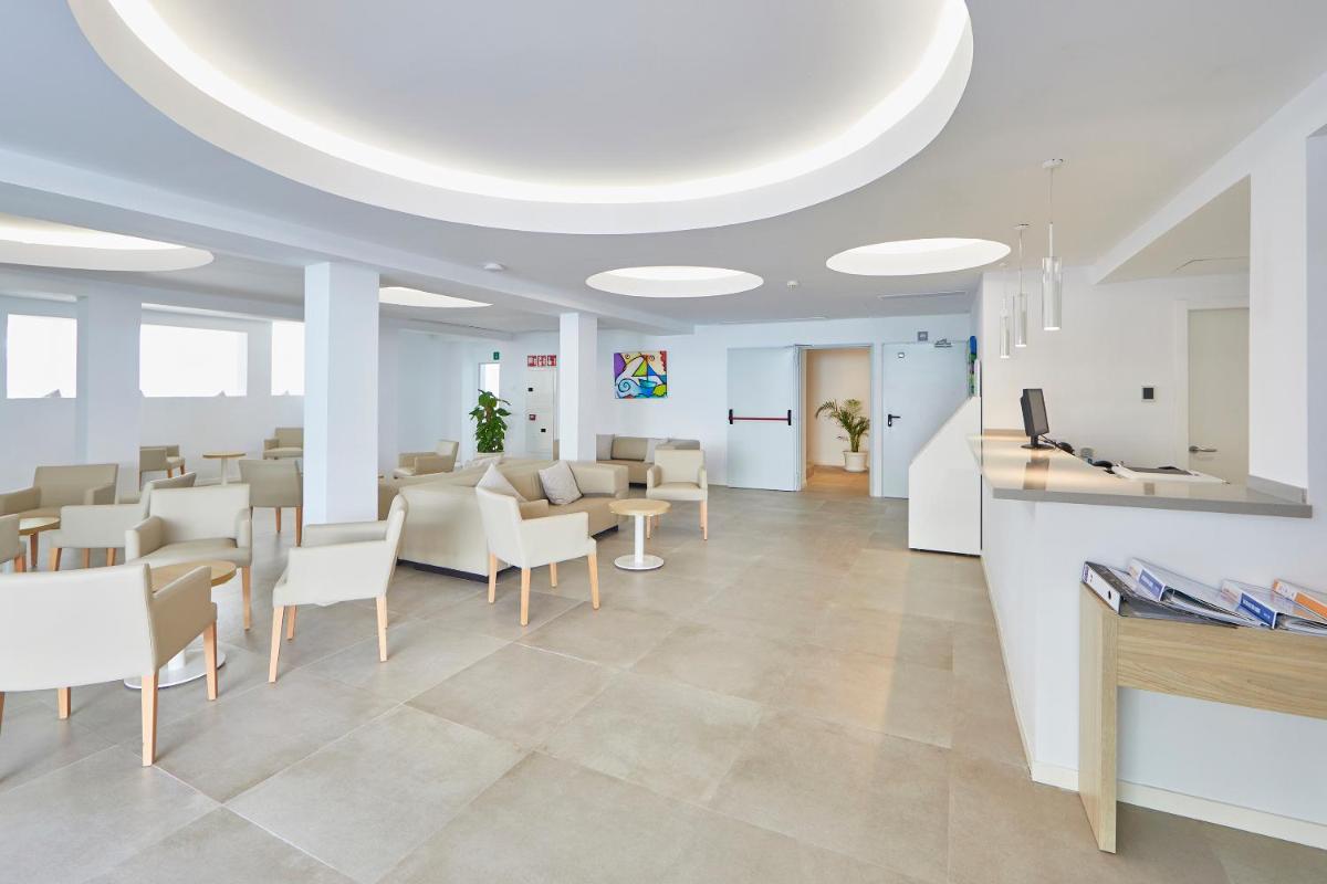 una oficina con una sala de espera con mesas y sillas en Hotel Ilusion Moreyo - Adults Only, en Cala Bona 75 fotos más