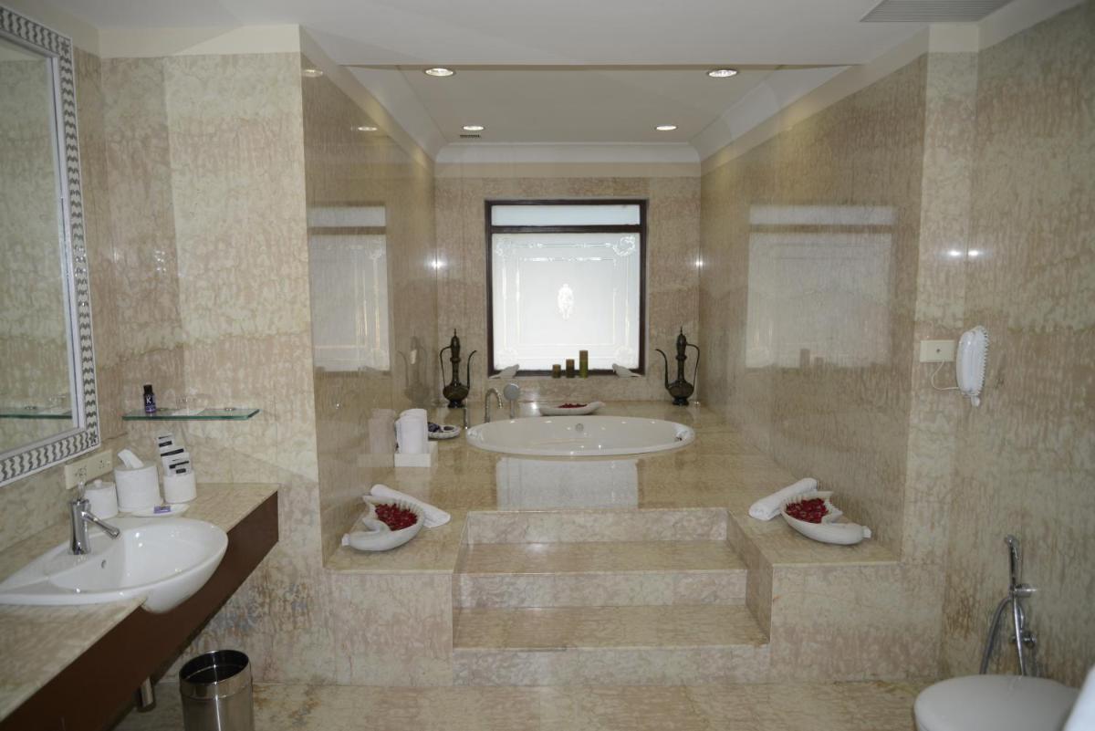 a large bathroom with two sinks and two mirrors at The Lalit Laxmi Vilas Palace in Udaipur