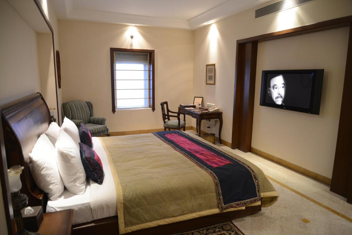 a hotel room with a bed and a television at The Lalit Laxmi Vilas Palace in Udaipur