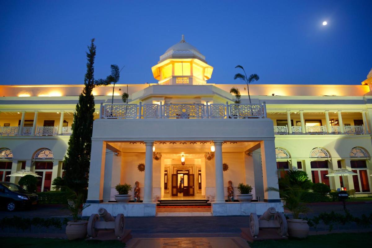 a large white building with a clock tower on top at The Lalit Laxmi Vilas Palace in Udaipur