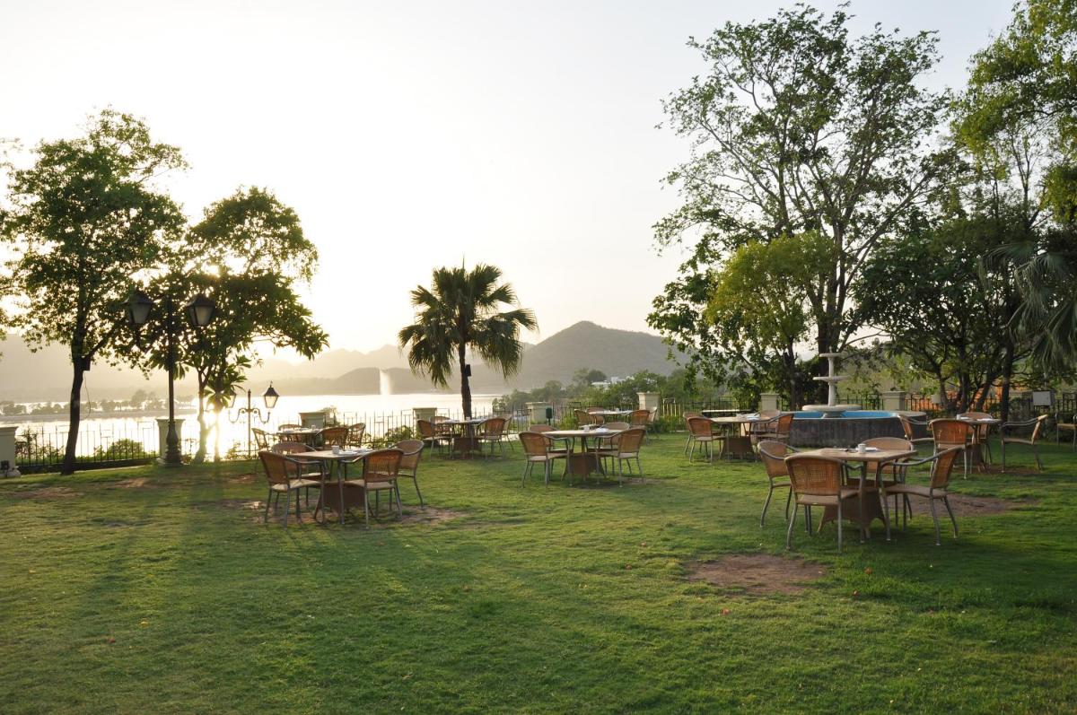 a group of tables and chairs in the grass at The Lalit Laxmi Vilas Palace in Udaipur