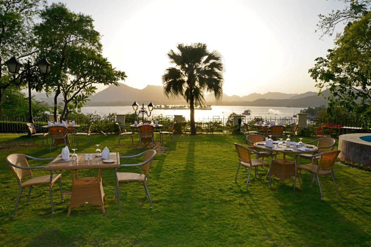 a group of tables and chairs with a view of the water at The Lalit Laxmi Vilas Palace in Udaipur