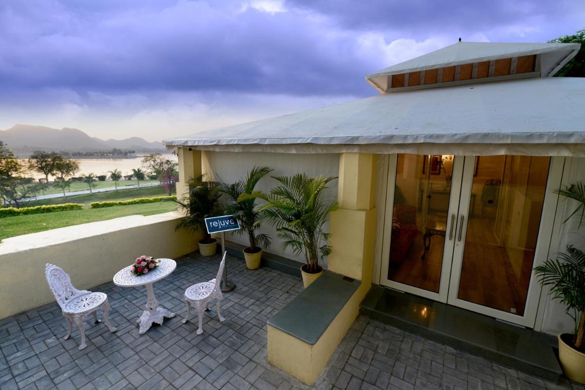 a building with a patio with chairs and a table at The Lalit Laxmi Vilas Palace in Udaipur