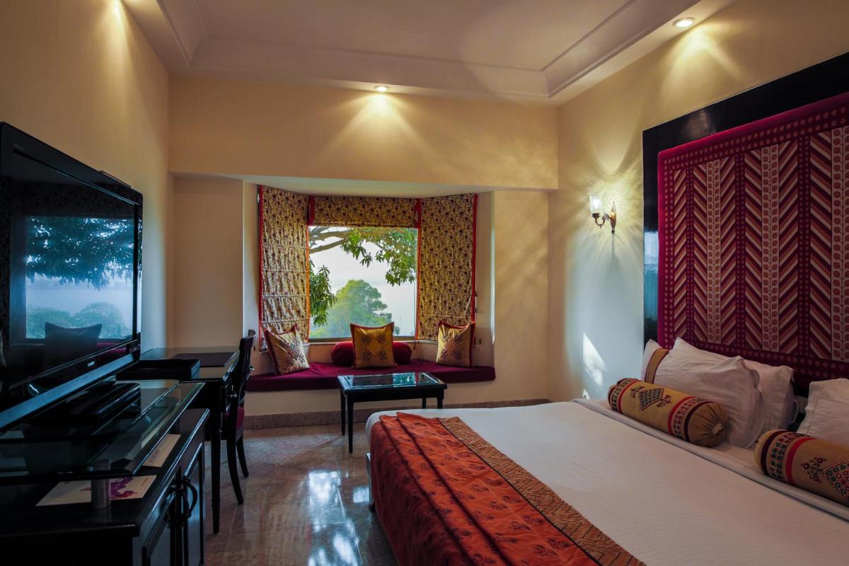 a hotel room with a bed and a window at The Lalit Laxmi Vilas Palace in Udaipur