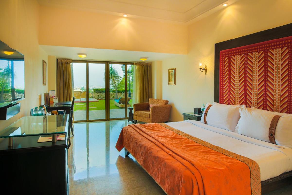 a hotel room with a bed and a desk at The Lalit Laxmi Vilas Palace in Udaipur