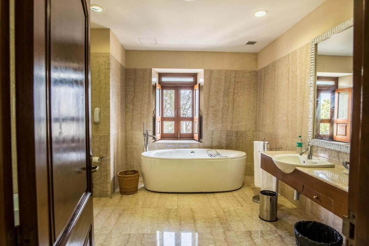 a large bathroom with a tub and two sinks at The Lalit Laxmi Vilas Palace in Udaipur