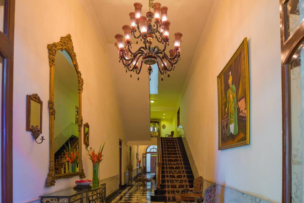 a hallway with a chandelier and stairs in a building at The Lalit Laxmi Vilas Palace in Udaipur