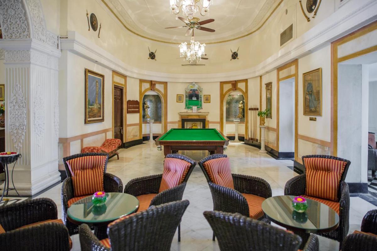 a room with tables and chairs and a pool table at The Lalit Laxmi Vilas Palace in Udaipur
