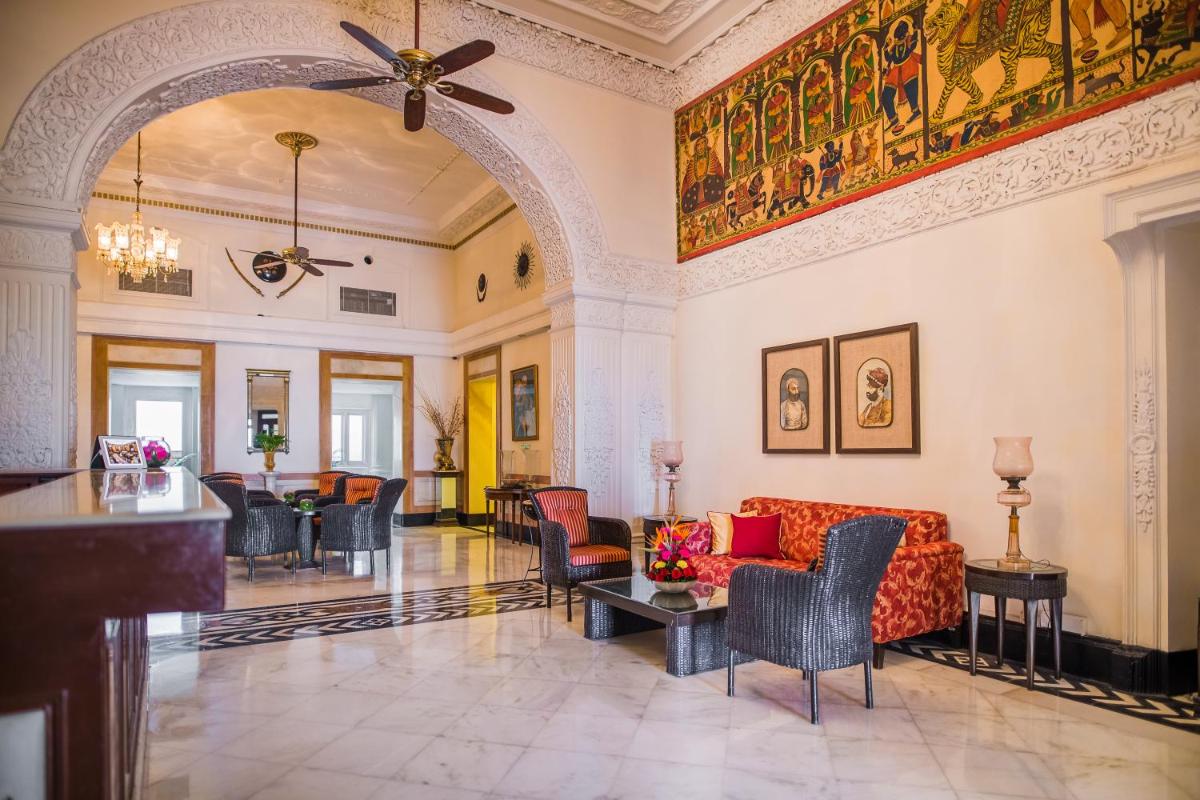 a lobby with a couch and chairs and a table at The Lalit Laxmi Vilas Palace in Udaipur