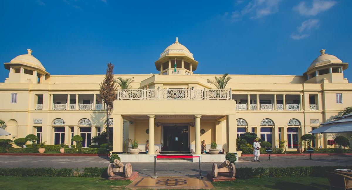 a large white building with people sitting in front of it at The Lalit Laxmi Vilas Palace in Udaipur