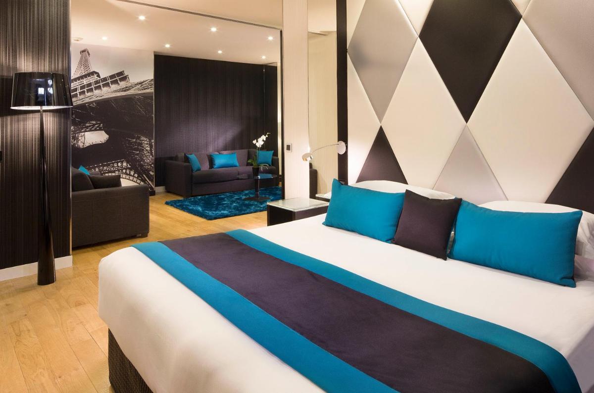 une chambre avec un grand lit aux oreillers bleus dans l'établissement L'Empire Paris - Louvre, à Paris