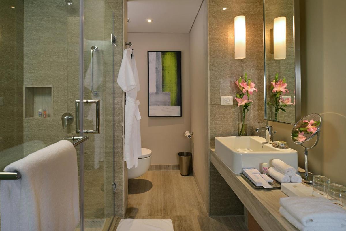 a bathroom with a sink and a toilet and a shower at Welcomhotel by ITC Hotels, Richmond Road, Bengaluru in Bengaluru