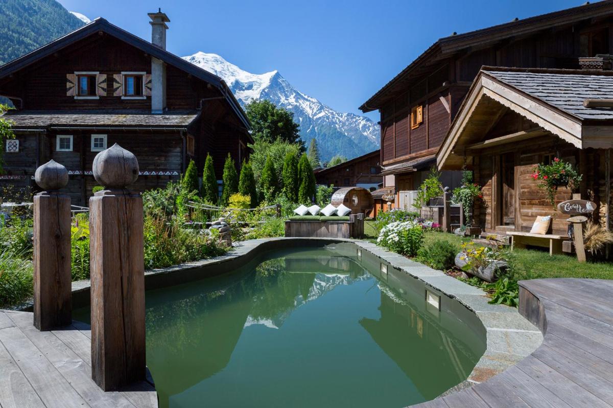 une maison avec une piscine devant une maison dans l'établissement Chalet-Hôtel Hermitage, à Chamonix-Mont-Blanc