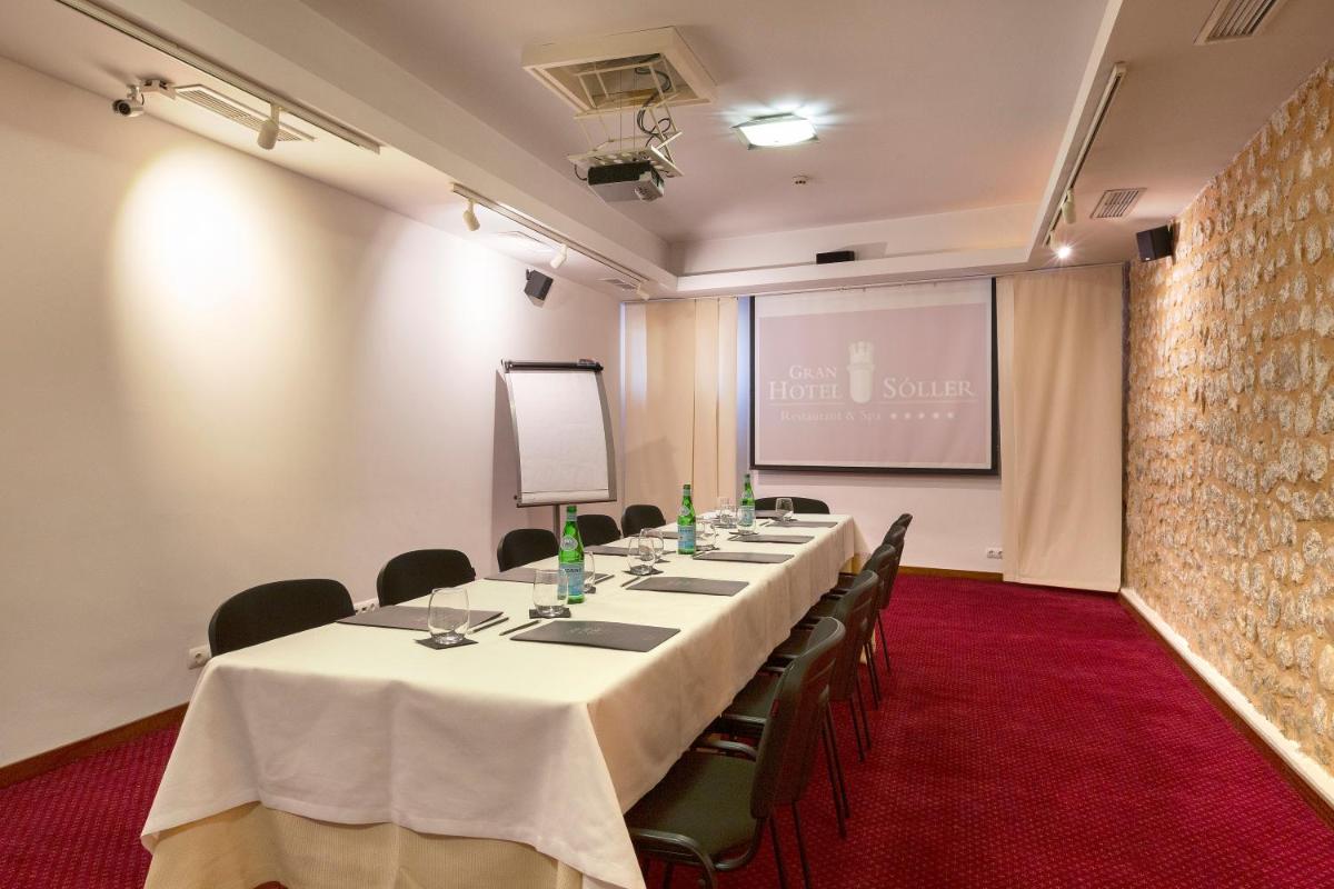una sala de reuniones con una mesa larga y sillas en Gran Hotel Soller, en Sóller