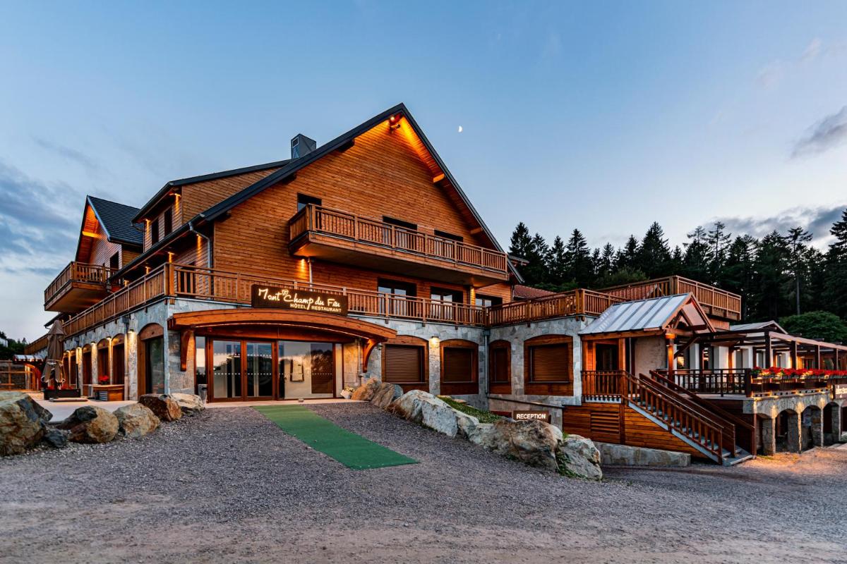 une grande maison en bois avec un porche et un balcon dans l'établissement Hotel Restaurant Mont Champ du Feu, à Belmont