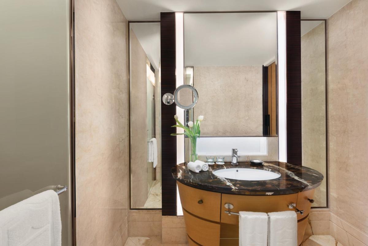 a bathroom with a sink and a mirror at Shangri-La Bengaluru in Bengaluru a bathroom with a sink and a mirror at Shangri-La Bengaluru in Bengaluru