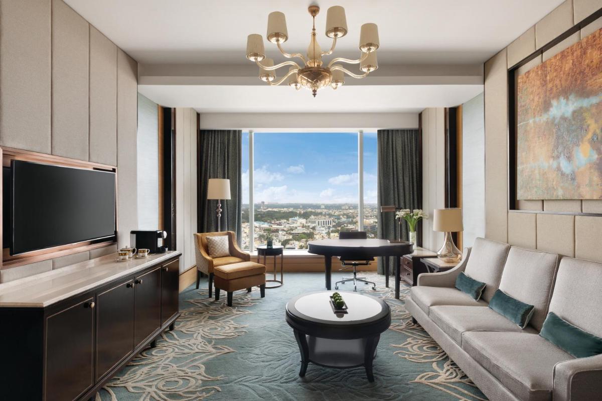 a living room with a couch and a tv at Shangri-La Bengaluru in Bengaluru a living room with a couch and a tv at Shangri-La Bengaluru in Bengaluru