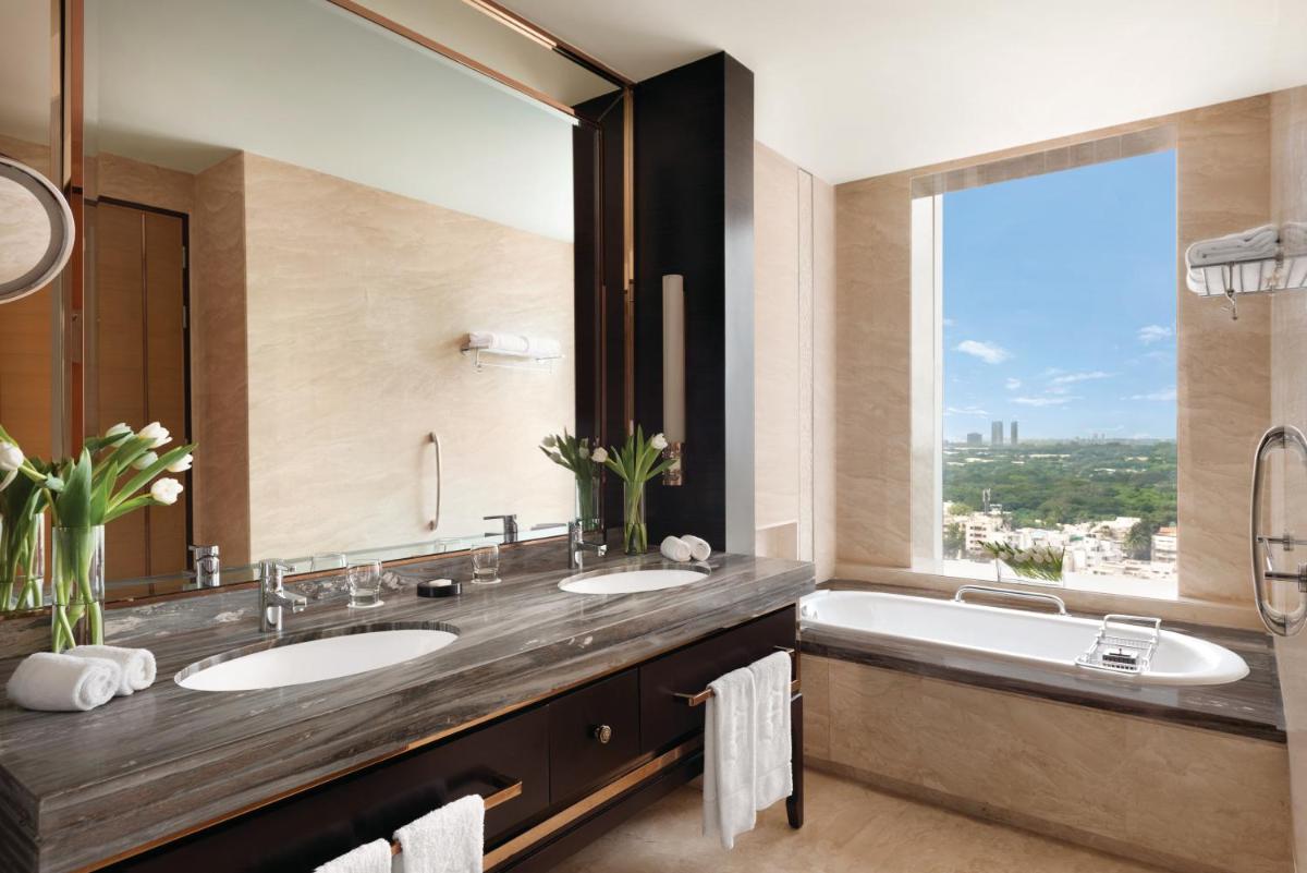 a bathroom with two sinks and a large window at Shangri-La Bengaluru in Bengaluru a bathroom with two sinks and a large window at Shangri-La Bengaluru in Bengaluru