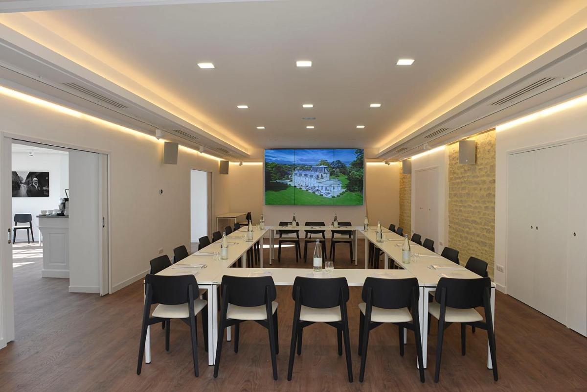 une salle de conférence avec une grande table et des chaises dans l'établissement Chateau La Cheneviere, à Port-en-Bessin-Huppain 37 autres photos