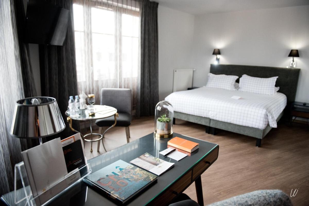 une chambre d'hôtel avec un lit et un bureau dans l'établissement Armes de Champagne, à Châlons-en-Champagne