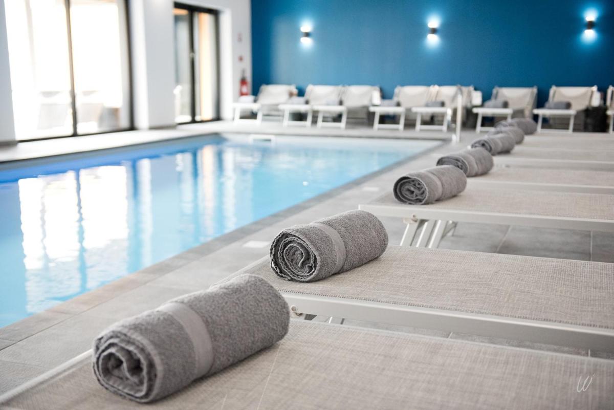 - une piscine avec plusieurs serviettes sur les pieds dans l'établissement Armes de Champagne, à Châlons-en-Champagne
