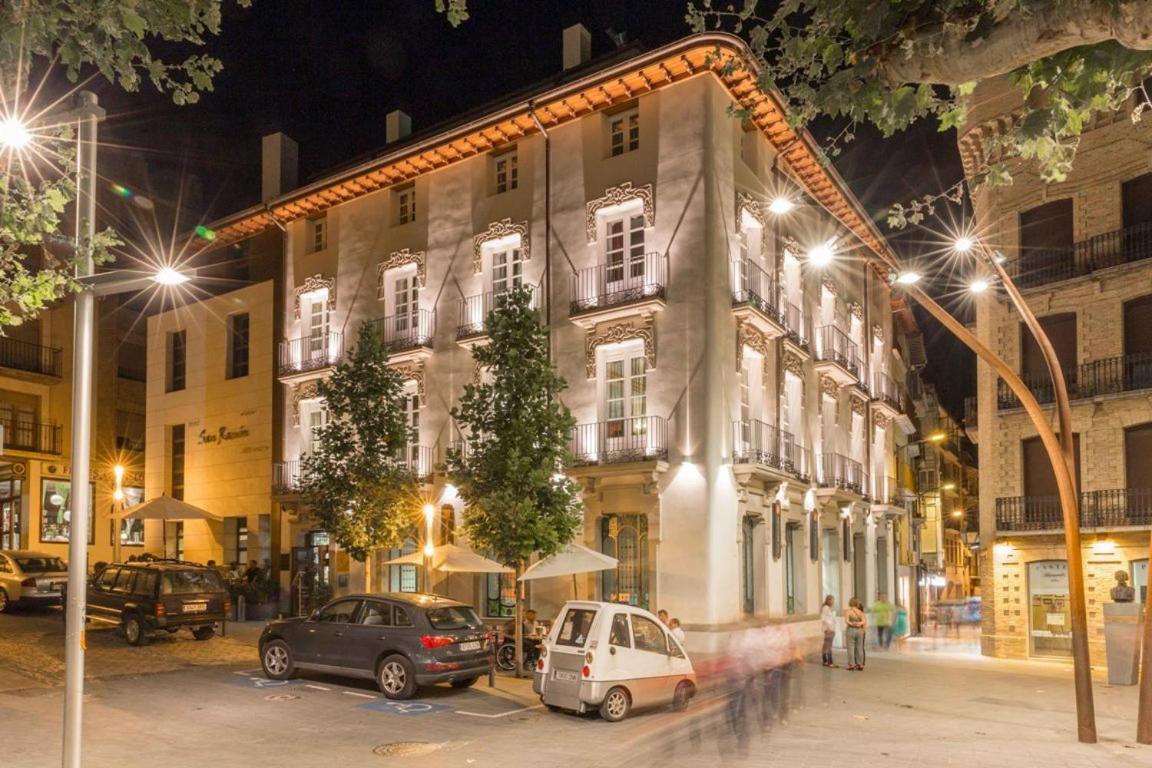 Dos coches aparcados delante de un edificio por la noche. en San Ramón del Somontano, en Barbastro