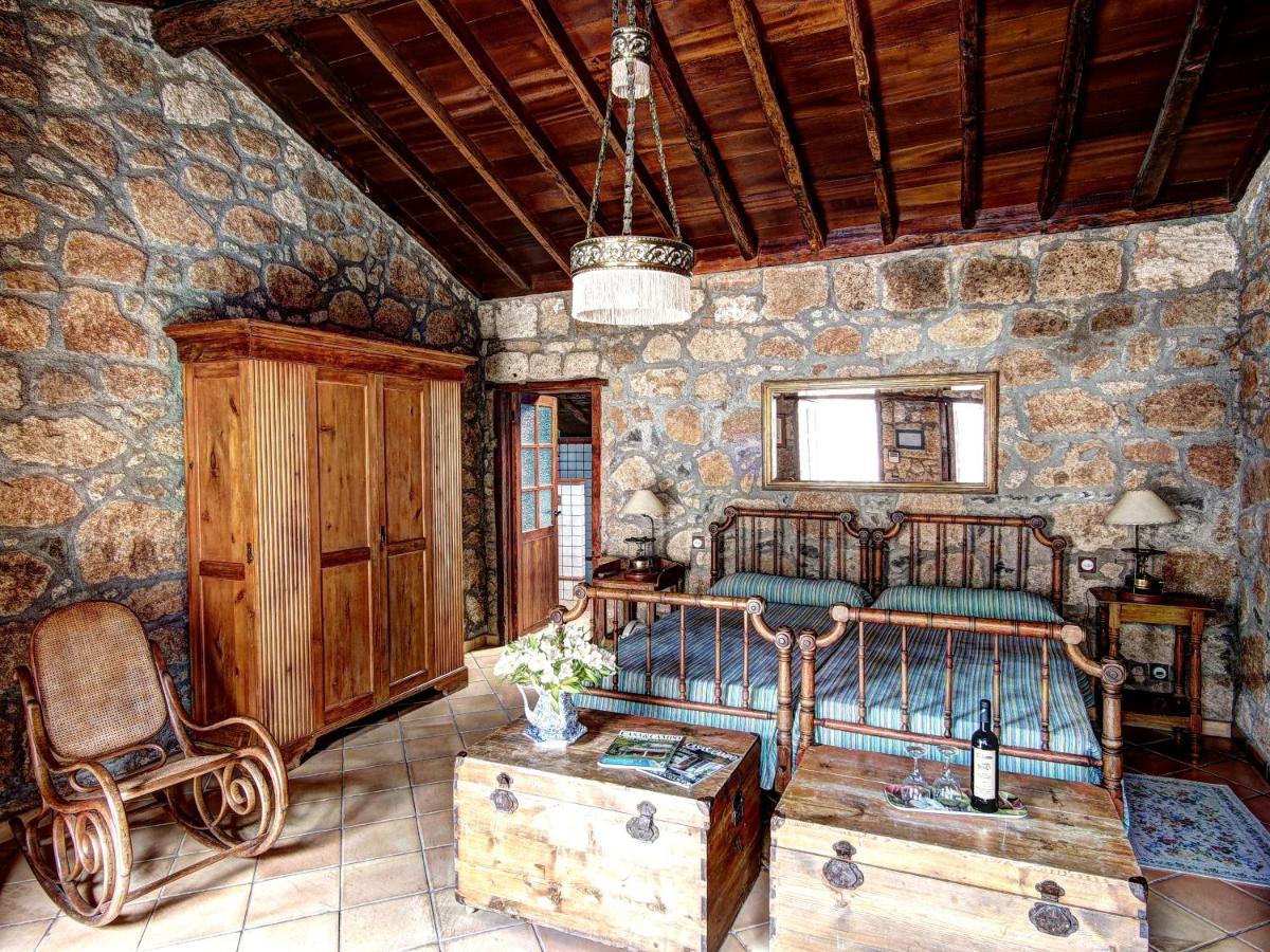 Un dormitorio con una cama en una pared de piedra. en Hotel Rural San Miguel - Only Adults, en San Miguel de Abona