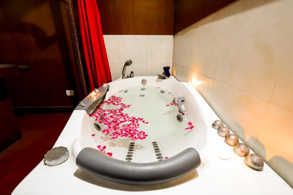 a bath tub filled with pink flowers in a bathroom at The Grand Imperial - Heritage Hotel in Agra