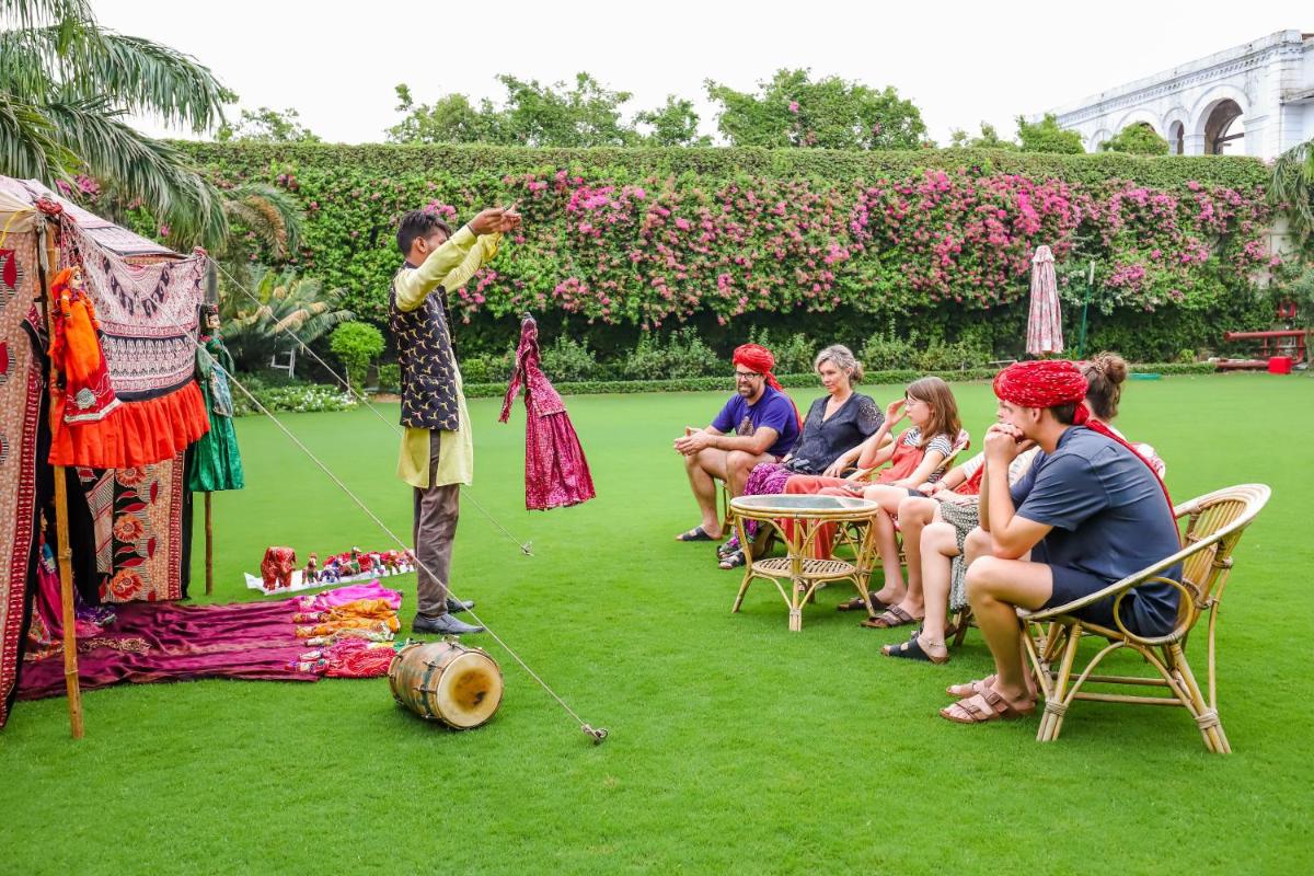 a group of people sitting on the grass at The Grand Imperial - Heritage Hotel in Agra