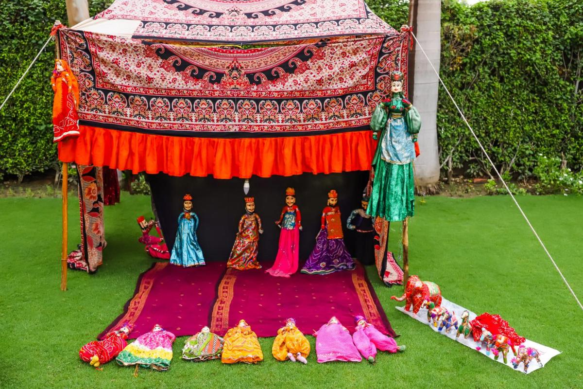 a group of figurines sitting on a rug in an umbrella at The Grand Imperial - Heritage Hotel in Agra